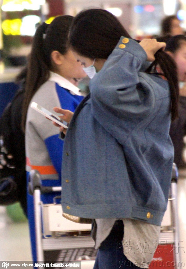 杨幂机场口罩遮面紧盯手机 休闲穿搭看似路人